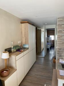 瓦勒迪泽尔白色天堂公寓的厨房铺有木地板,配有白色橱柜。