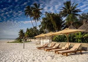 马特姆维Alladin Boutique Beach Hotel and SPA Zanzibar的海滩上一排带遮阳伞的沙滩椅