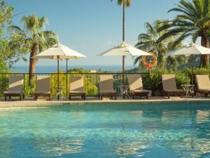 德阿埃斯莫里酒店的一个带椅子和遮阳伞的游泳池