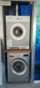 特玛斯德戴曼Squania Suite Container & Monoambientes的洗衣机位于洗衣机顶部