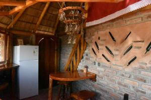 Treinta y TresLa Oca en el Cielo的厨房设有砖墙、桌子和冰箱