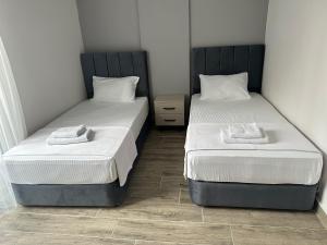 卡赫拉曼马什拉MARASIUM SUITES的两张睡床彼此相邻,位于一个房间里