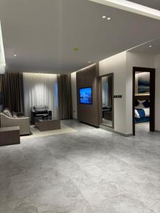 利雅德الحزم للشقق الفندقية - الرياض - العليا的带电视的酒店客房和客厅
