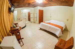 伊基托斯奥罗维尔支套房酒店的一间卧室配有一张床、一个浴缸和一个水槽