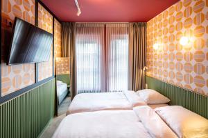 阿姆斯特丹经济型旅游酒店的一间卧室配有一张床和一台平面电视