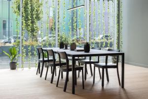 伦敦Zedwell Greenwich的黑色用餐室桌椅,种有植物