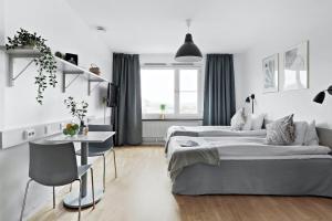 斯德哥尔摩斯德哥尔摩阿尔维克弗里农公寓式酒店的白色卧室配有两张床和一张桌子