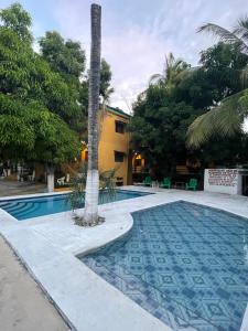埃斯孔迪多港Hotel Posada Playa Manzanillo的一座游泳池,旁边是一座棕榈树
