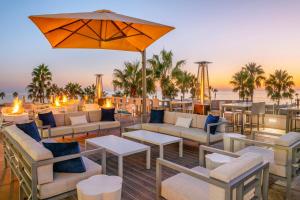 卡尔斯巴德SpringHill Suites by Marriott San Diego Carlsbad的一个带沙发和桌子及遮阳伞的庭院