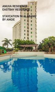 马尼拉Staycation in Alabang By Angela的一座高楼前的大型游泳池