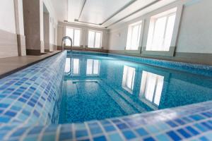 若夫克瓦Hotel Kopa - Zhovkva的一座蓝色瓷砖的游泳池