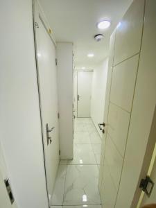 迪拜SKY 9 Hostel ,UNION METRO的走廊设有白色墙壁和白色瓷砖地板。