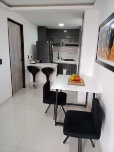 卡塔戈Apartamento de lujo , con linda vista, cuarto piso的厨房配有白色的桌子和黑色的椅子