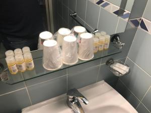 沙勒维尔-梅济耶尔塞萨尔酒店的浴室配有盥洗盆、带洗浴用品的架子