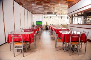 伊基托斯奥罗维尔支套房酒店的一间带红色桌椅和电视的用餐室