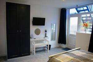 绍斯波特Dolce Central Lord St. Flat 1的一间卧室设有一张床、一台电视和一个窗口。