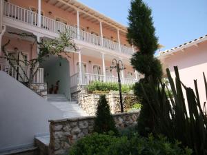 阿约斯尼奇塔斯Ionis Hotel的一座大型粉红色建筑,有楼梯和植物