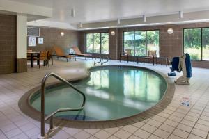 维斯塔宾厄姆顿万怡酒店的酒店大堂的大型游泳池配有桌椅