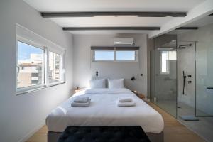 雅典One Shade of Grey Loft with Private Terrace的卧室配有一张白色大床和玻璃淋浴间