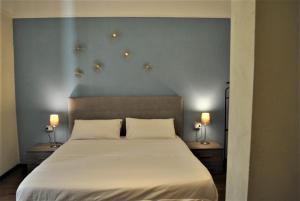 普拉托Appartamento Guido的一间卧室配有一张带两个枕头和两个灯的床。