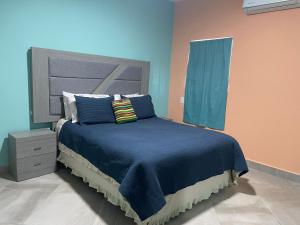 佩尼亚斯科港Condominio puerto peñasco 2的一间卧室配有一张带蓝色床单和枕头的床。