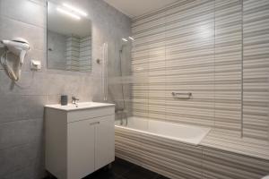 法鲁Leevin Guesthouse的带浴缸、水槽和淋浴的浴室