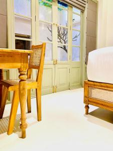 高尔Ivy Lane Galle Fort的客房设有桌子、椅子和窗户。