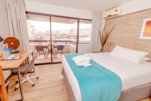 伊基克Hotel Gavina Costa Mar的配有一张床、一张桌子和一张桌子的酒店客房