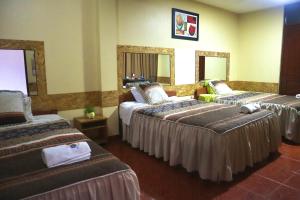 瓦努科HOSTAL SOL & LUNA的酒店客房带两张床和两面镜子