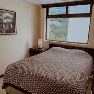 帕纳哈切尔Apartamento Torres de Atitlan的一间卧室设有一张床和一个大窗户