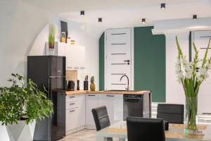拉德库夫Apartament w Rynku II, MyWeek的厨房配有白色橱柜和黑色冰箱。