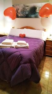 莫雷拉Casa Placet de Sant Joan Apto的一张带紫色棉被和毛巾的床