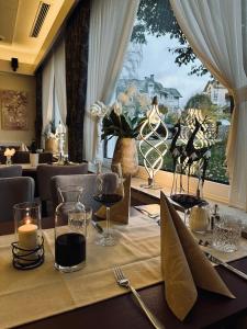 温特贝格佛斯豪斯酒店的餐厅的一张桌子,上面放着酒杯,还有一个窗户