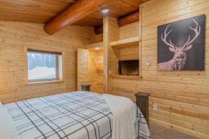 费尔班克斯The Alaskan Dream Lodge的卧室配有一张床,墙上挂着鹿的照片