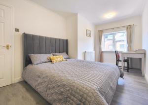 曼彻斯特Regent House - Modern Holiday Home 10 Minutes to Manchester City Centre With Free Parking的一间卧室配有一张大床和一张书桌