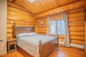 费尔班克斯Tucked Away Timber Upper Suite的卧室配有一张床铺,位于带木墙的房间内
