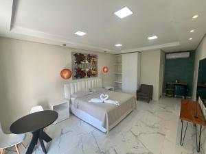 博阿维斯塔Villa'S Roraima - Pousada & Natureza的卧室配有一张床和一张桌子及椅子