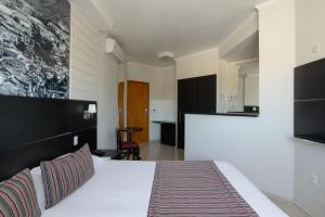 陶巴特Faro Hotel Taubaté的酒店客房带一张床和一个厨房