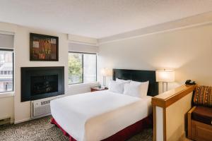 惠斯勒惠斯勒山边公寓式酒店的酒店客房设有一张大床和一个壁炉。