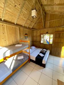 普腊亚罗萨Pousada Lua de Java - Casa Bali的配有木天花板的客房内的两张床