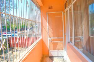 哈拉雷Fantastic location 1-Bed Apartment in Harare的橙色的外墙,带有窗户