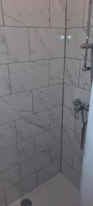 列日Super appartement près des commodités的一间带淋浴的浴室,铺有白色的瓷砖墙