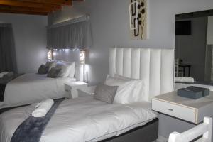 博克斯堡Villa La Sola B&B and Self-Catering的一间卧室配有两张床和一张书桌
