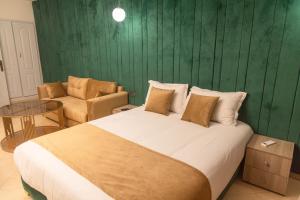 马拉喀什Residence La Perle de l'Atlas Marrakech的一间卧室设有一张大床和绿色的墙壁