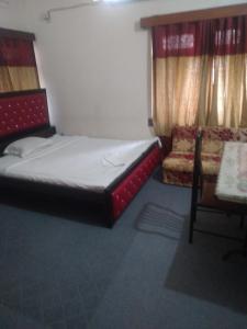 达卡Taz Garden House的一间小卧室,配有一张床和一把椅子