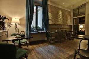 的里雅斯特福尔姆精品酒店的一间带桌椅的用餐室和窗户。