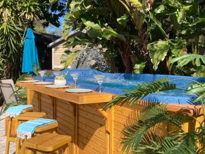 帕姆港3Gulls Inn Ozona-Boutique Hotel-Steps from Restaurants & Brewery-SwimSpa Pool-Pet Friendly的一张带椅子的木桌和一个游泳池