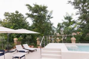 塞维利亚Cavalta Boutique Hotel GL的一个带游泳池、椅子和遮阳伞的庭院