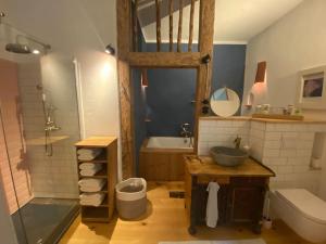 坡瑟利特兹Wohnung in historischem Pfarrhof auf Rügen的浴室配有水槽、淋浴和浴缸。