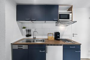 金茨堡ADN Suites - NETFLIX - modern and smart的厨房配有蓝色橱柜和水槽